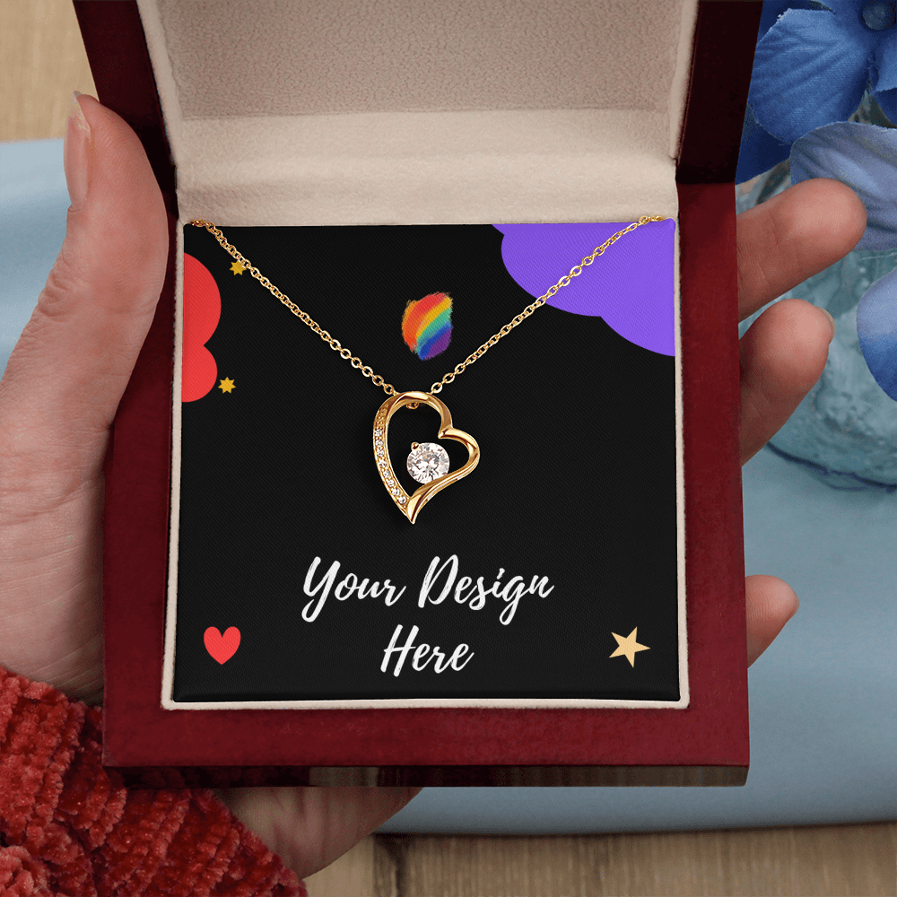 Hand holding an open red velvet jewelry box with a gold heart-shaped pendant necklace and customizable design card