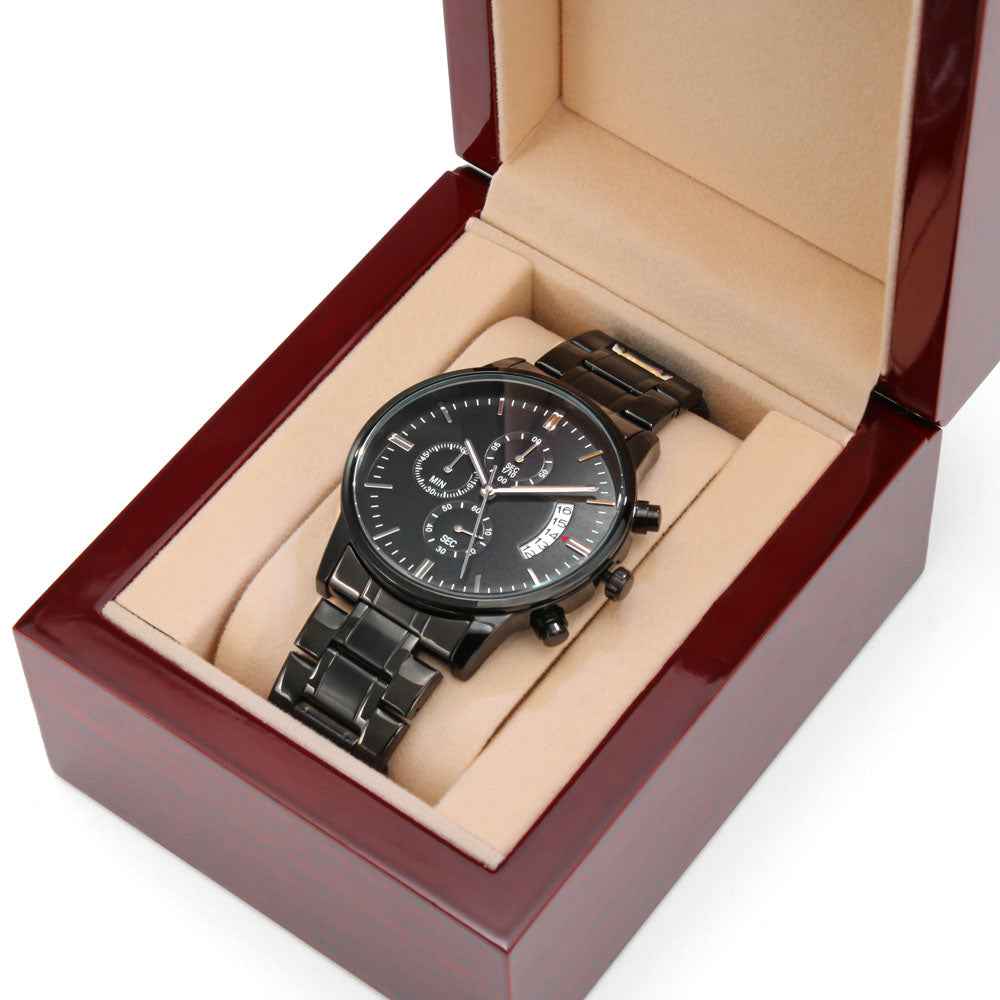 Black metal chronograph wristwatch with date display in beige cushioned wooden box