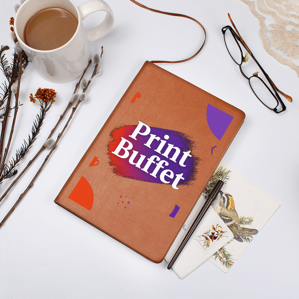 Brown leather notebook with Print Buffet logo, coffee cup, eyeglasses, pen, and botanical prints on white surface