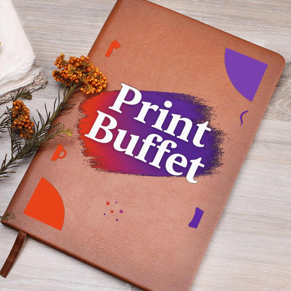 Brown leather journal with colorful design and text Print Buffet on wooden table with orange flowers