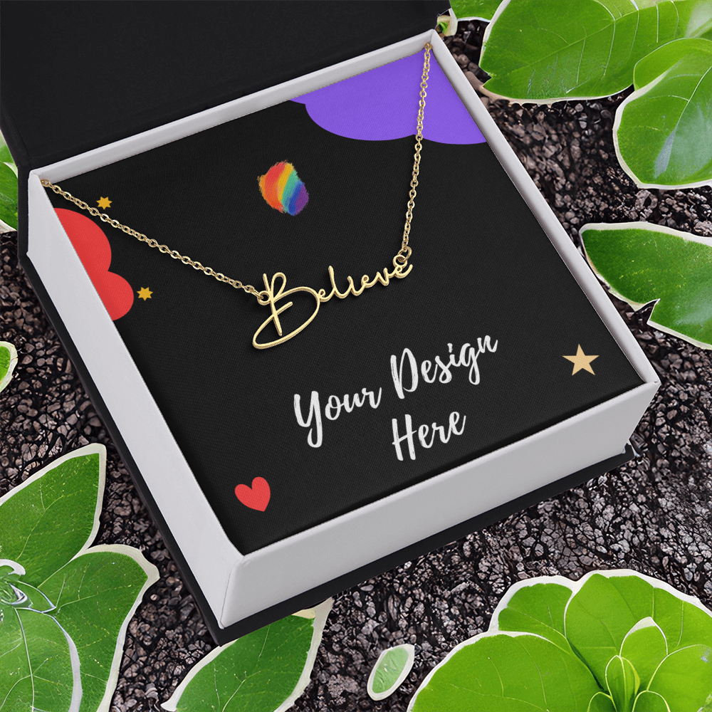 Gold believe necklace in black box with Your Design Here text, surrounded by green leaves on textured surface