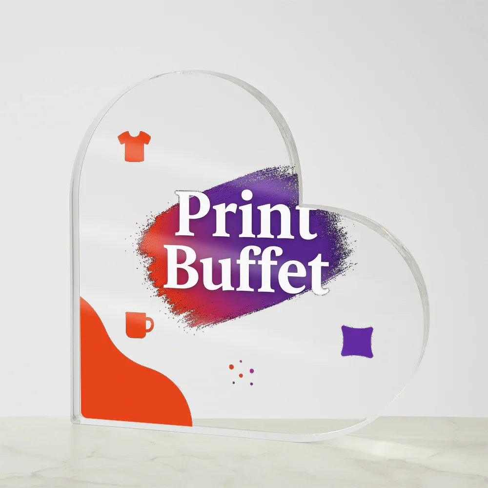 Clear heart-shaped acrylic sign with colorful Print Buffet logo and icons on marble surface