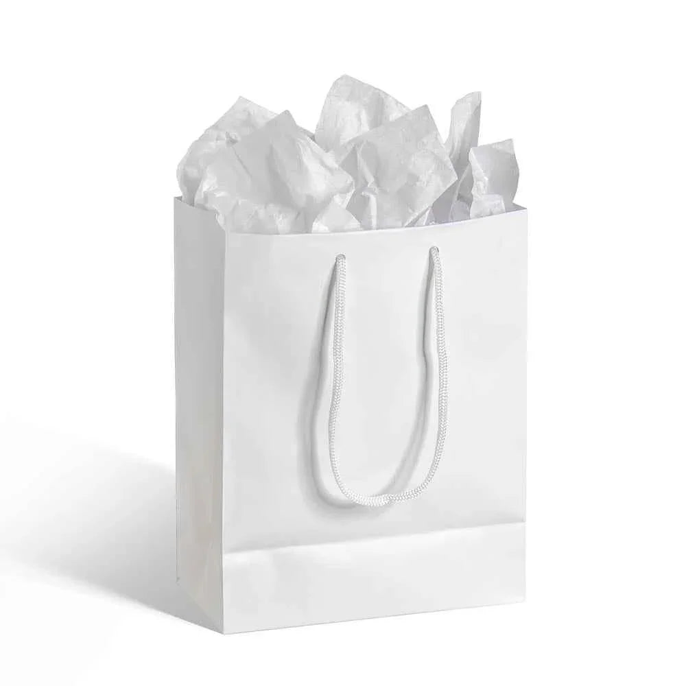 White paper gift bag with white rope handles filled with crumpled white tissue paper