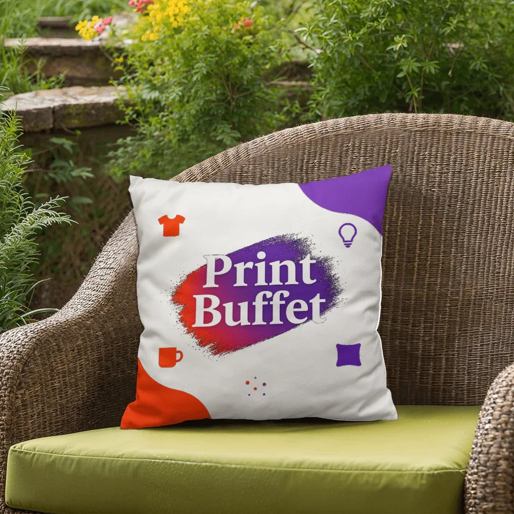 White decorative pillow with Print Buffet logo in red and purple on wicker chair in garden