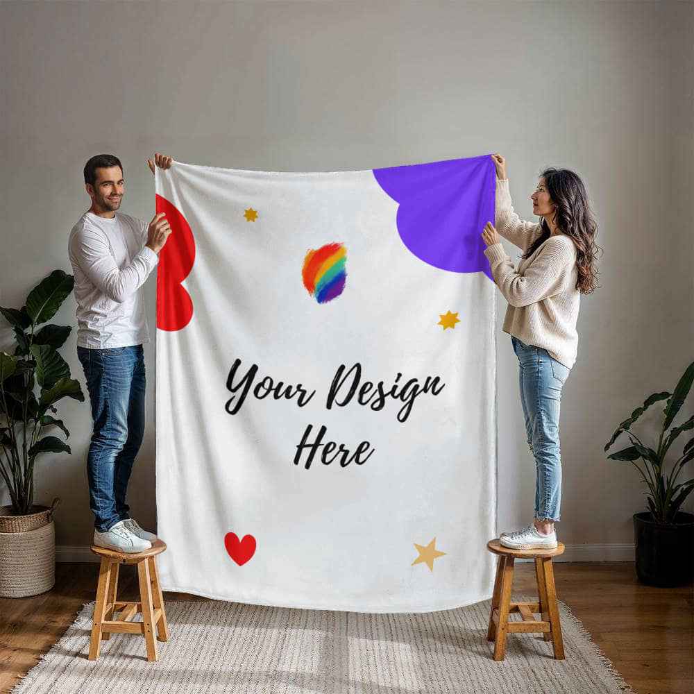 Man and woman standing on stools holding custom white design blanket with colorful shapes indoors