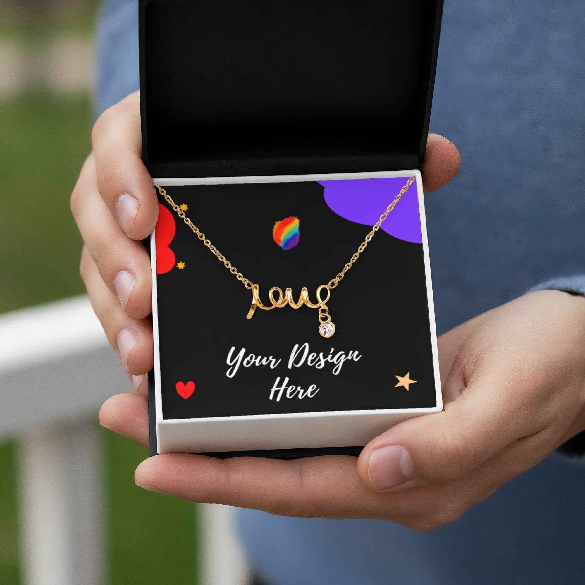 Hands holding an open black jewelry box with a gold name necklace and text Your Design Here