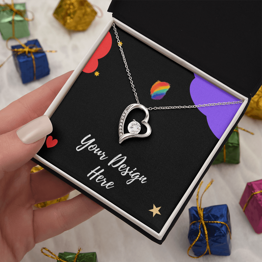 Hand holding a gift box with a silver heart pendant necklace on black fabric reading Your Design Here