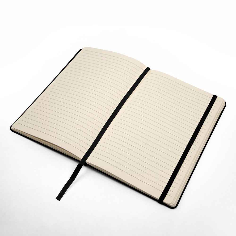 Open lined notebook with black elastic band and ribbon bookmark on white background