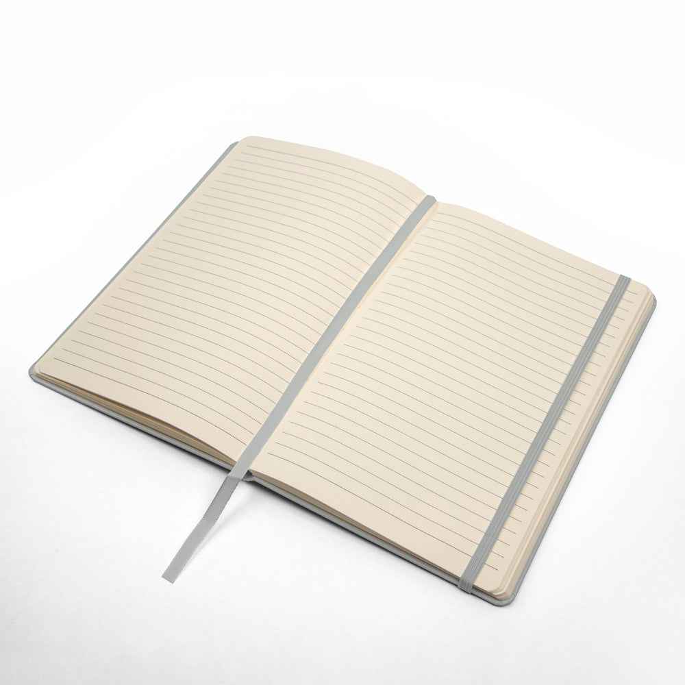 Open lined notebook with grey fabric bookmark and elastic band on white background
