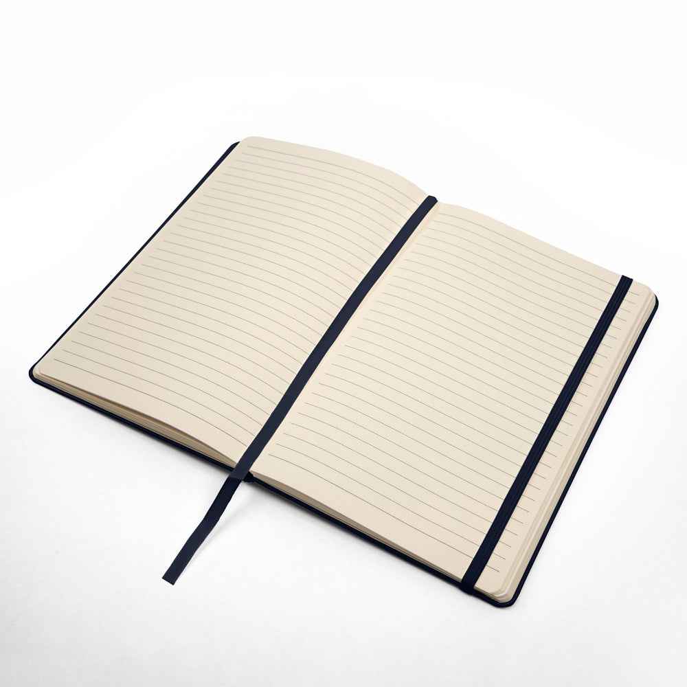 Open lined notebook with black elastic strap and bookmark on white background