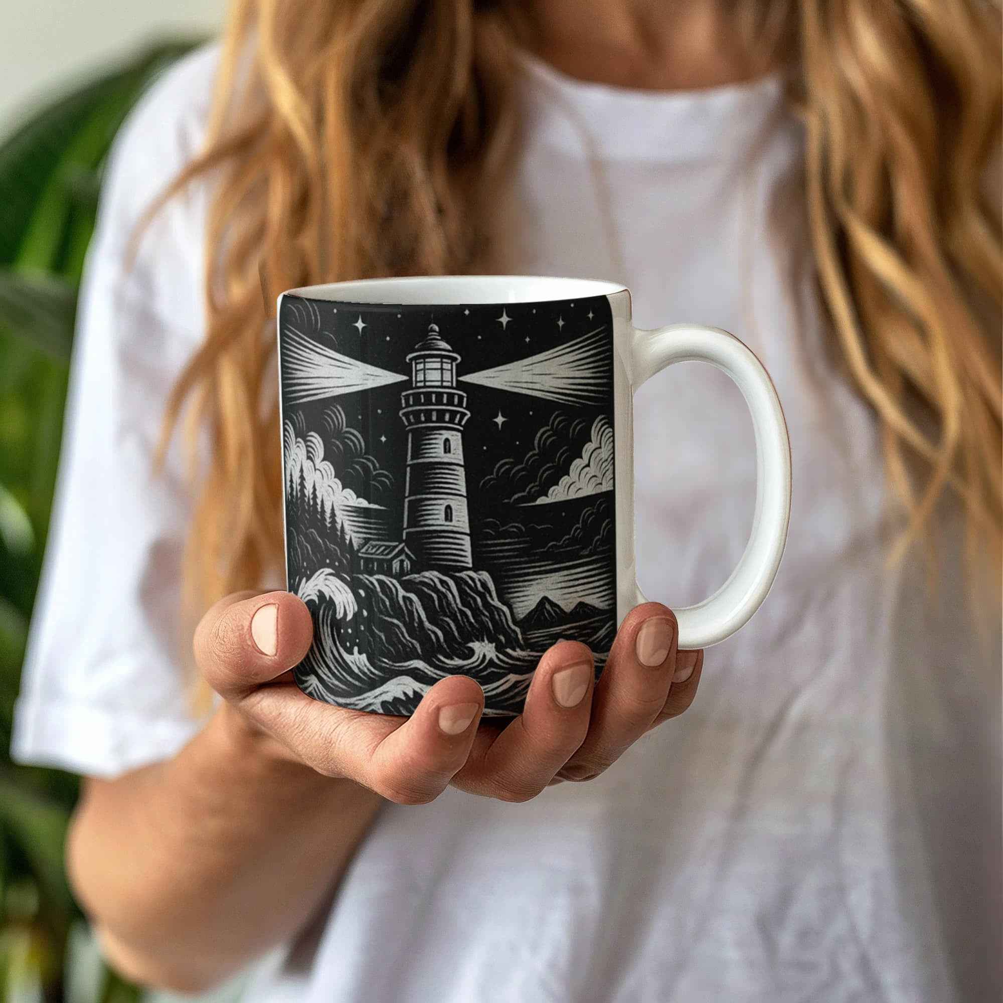 Hand holding black and white ceramic mug with detailed lighthouse and ocean wave design