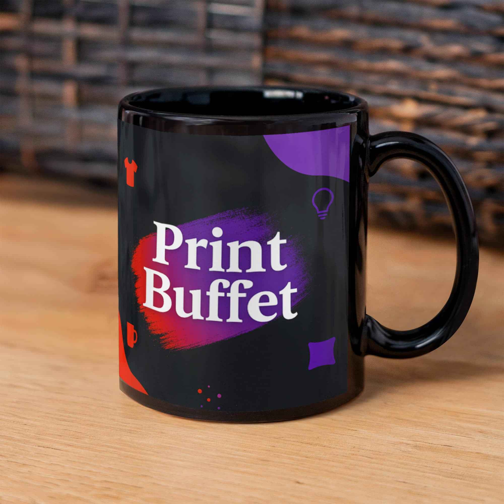 Black ceramic mug with Print Buffet logo and colorful design on wooden surface