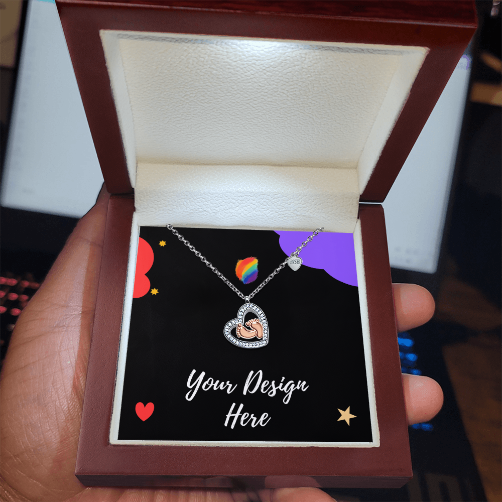 Hand holding open jewelry box with heart-shaped baby feet pendant necklace and custom design insert